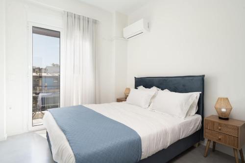 a white bedroom with a large bed and a window at Revived Urban Charm - 1BR in Athens