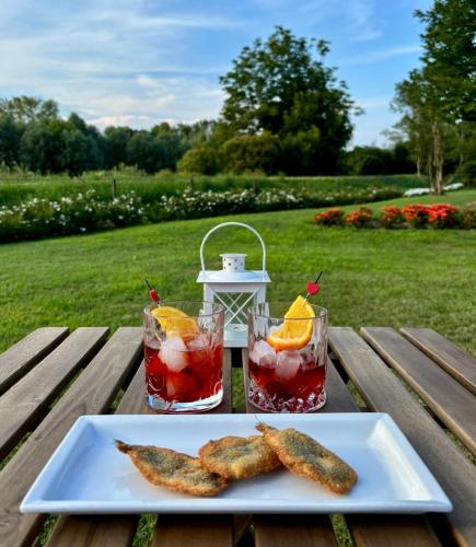 a table with two drinks and a plate of food at Borgo Cà dei Sospiri in Quarto dʼAltino
