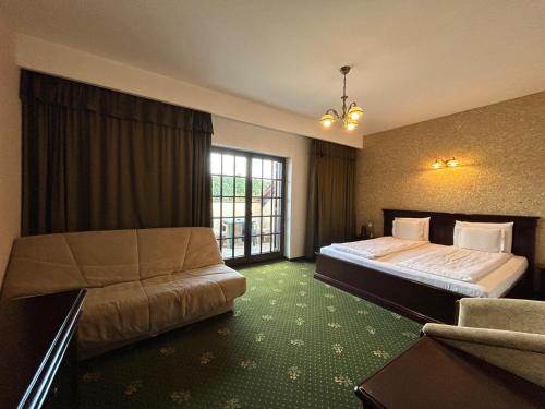 a hotel room with two beds and a couch at Popasul Caprioarei in Pădureni