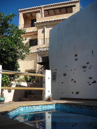 a building with a swimming pool in front of a building at Casa El Garzopo ,especial,acogedora y confortable in Órgiva