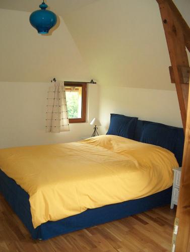 - une chambre avec un lit doté de draps jaunes et une fenêtre dans l'établissement Superb barn conversion in the golden triangle Pont l'Evêque-Honfleur-Deauville, à Saint-Julien-sur-Calonne