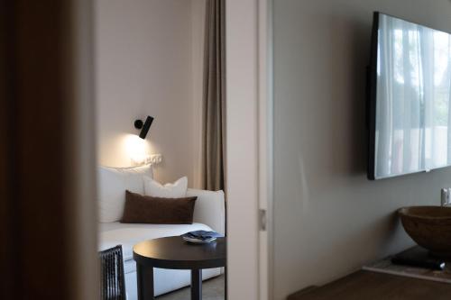 a hotel room with a white couch and a table at Asterion Suites & Spa - Designed for Adults in Gerani Chanion