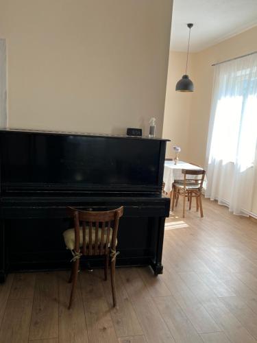 a black piano in a living room with a table at Duplex in Arinj in Arrinj