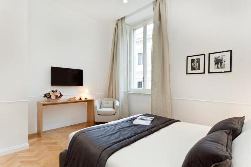 a bedroom with a bed and a chair and a television at Vanity Hotel Navona in Rome