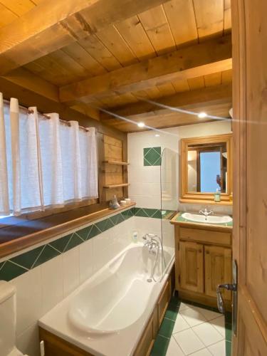 une salle de bain avec une baignoire et un lavabo dans l'établissement Appartement 1004 Grand Sud, à Courchevel