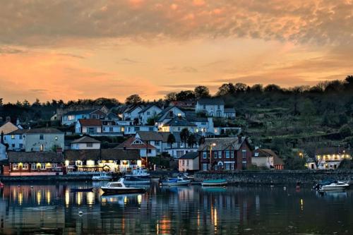 a town with boats in the water at sunset at Oyster Cottage in Cockwood