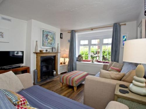 a living room with a couch and a fireplace at Oyster Cottage in Cockwood
