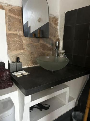 une salle de bain avec un lavabo et un miroir sur un comptoir dans l'établissement Ancienne petite bastide provençale, à Sanary-sur-Mer