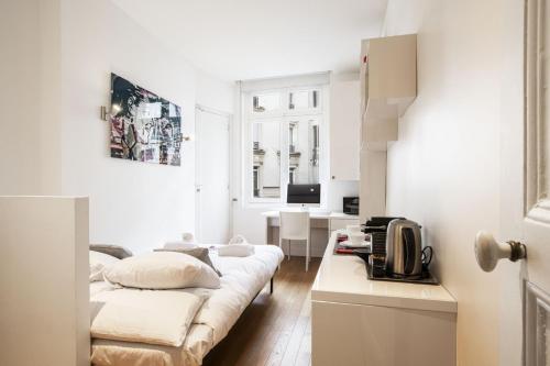 - un salon avec des murs blancs et un canapé dans l'établissement Tiny House St Germain, à Paris