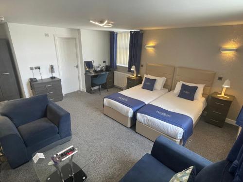 a hotel room with a bed and a desk and chairs at Ruskin Hotel in Blackpool