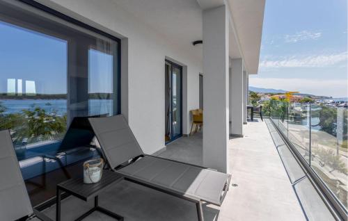a balcony with a chair and a view of the water at Lovely Home In Rab With House Sea View in Rab