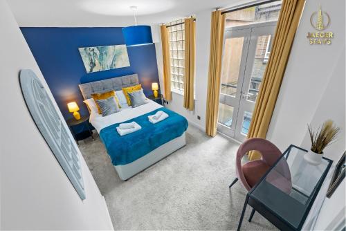 a blue bedroom with a bed and a chair at 2 Bedroom Greek Street Apartment - Sleeps 6 in Leeds