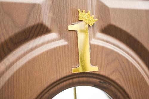 a gold number one with a star on a wall at Apartmani P7 in Dračevo