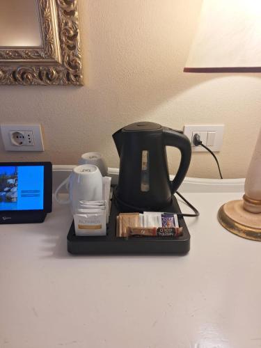 a coffee maker sitting on a table next to a lamp at Hotel Borgo Di Cortefreda - Place of Charme in Tavarnelle in Val di Pesa