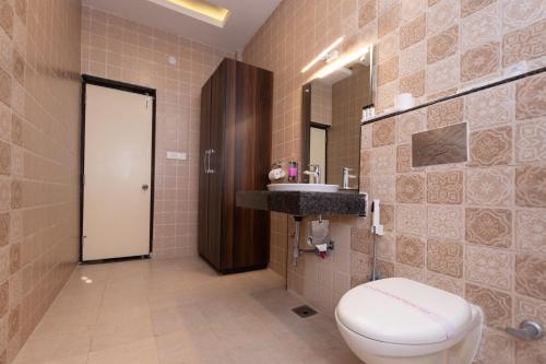 a bathroom with a toilet and a sink at Indira Nikunj Rubystone Exotic in Rishīkesh