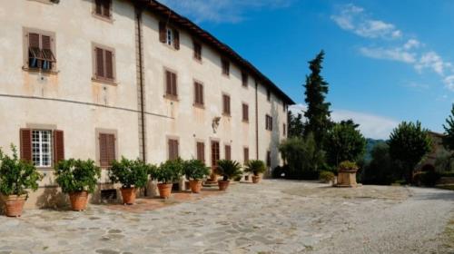 a large building with potted plants in front of it at Luna - Villa Cenami - big POOL with view in Corsanico-Bargecchia