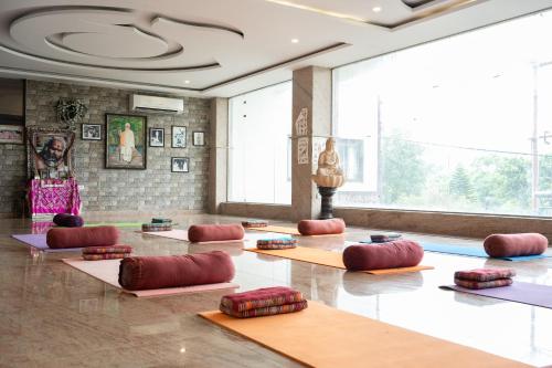a yoga room with red pillows on the floor at Indira Nikunj Rubystone Exotic in Rishīkesh