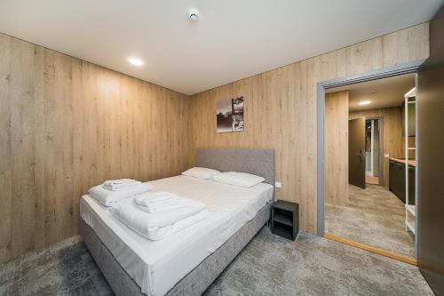 a bedroom with a large bed with white sheets at Zaliakalnio Terasos apartamentai 2 in Kaunas