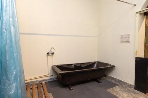 a bathroom with a black bath tub in a room at Indira Nikunj Rubystone Exotic in Rishīkesh