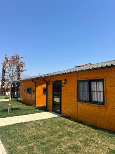 a small orange building with a door and grass at Some Hotel Antakya in Hatay