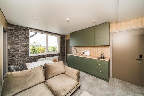 a living room with a couch and a kitchen at Zaliakalnio Terasos apartamentai 2 in Kaunas
