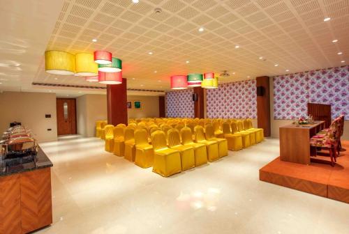 a conference room with yellow chairs and a table at Park Residency Puthuppally in Putuppalli