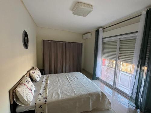 a bedroom with a bed and a large window at Résidence la rosée in Mamoudzou