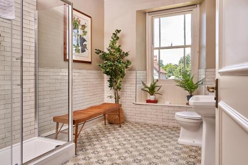 a bathroom with a shower and a toilet and a window at The Langford Inn in Langford