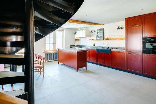 a kitchen with red cabinets and a kitchen island at Luxury Residences by Widder Hotel in Zürich