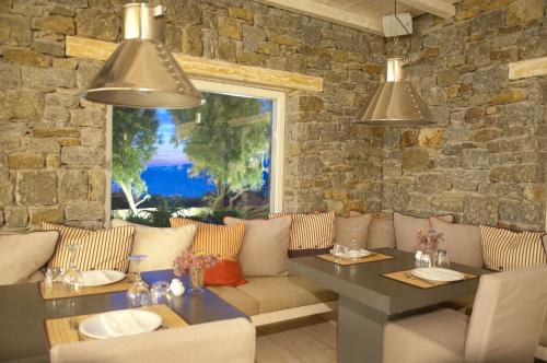 a dining room with a table and a stone wall at Vencia Boutique Hotel in Mýkonos City