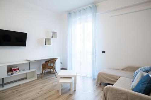 a white living room with a couch and a table at Lupo di Mare by Wonderful Italy in Savona