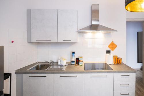 a kitchen with white cabinets and a sink at Lupo di Mare by Wonderful Italy in Savona