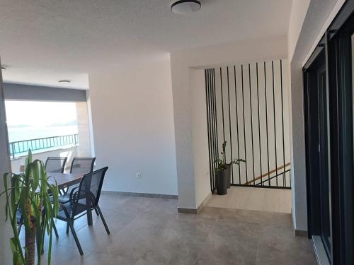 a dining room with a table and chairs and a balcony at Apartmani Srdarović in Drage