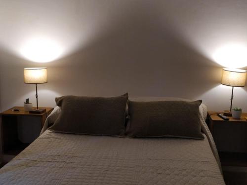 a bedroom with a bed with two lamps on it at Hostal El soleado in Navarro