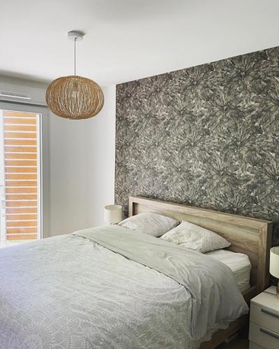 - une chambre avec un grand lit et une fresque murale dans l'établissement L'Hibiscus - centre ville - parking - 3p, au Mans