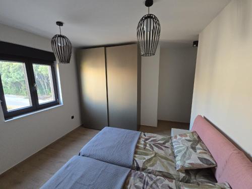 a bedroom with two pendant lights and a bed at Penthouse HEDONIST with hidromassage bath in Pula