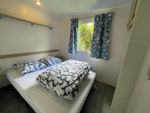 une petite chambre avec un lit et une fenêtre dans l'établissement Chez Roger - Bungalow climatisé avec TV - 2 chambres 4 personnes, à Boofzheim