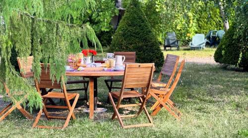 een houten tafel met vier stoelen eromheen bij La Chambre des Châteaux in Cellettes