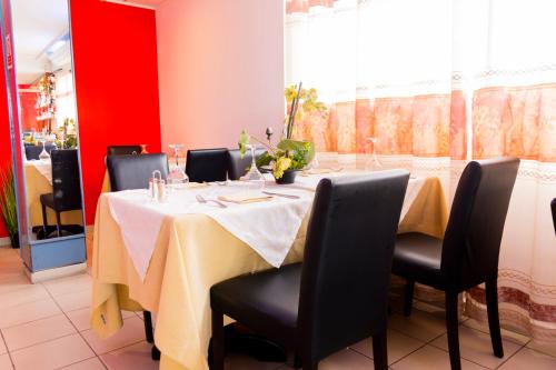 a dining room with a table with black chairs at Bano Palace Hotel in Douala
