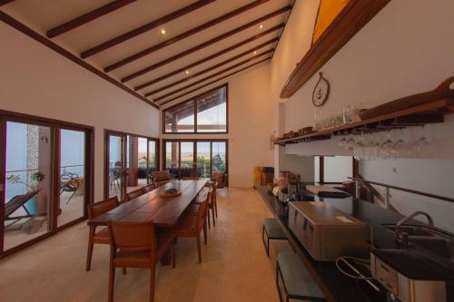 una cucina con un lungo tavolo in legno e sedie di Taiba Beach Resort a Taíba