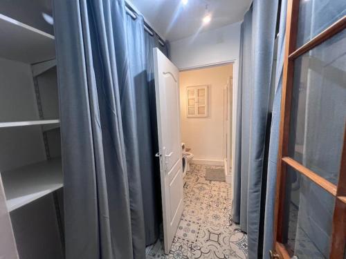 La salle de bains est pourvue de rideaux bleus et de toilettes. dans l'établissement Charmant T2 Provençal, à Aix-en-Provence