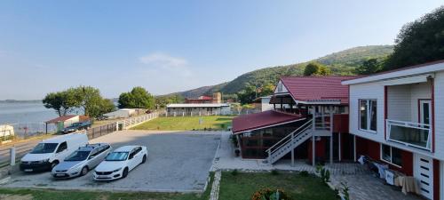 two cars parked in a parking lot next to a house at Casa Legrand in Baziaş