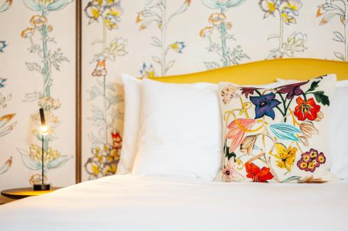 a bedroom with a white bed with a yellow headboard at Luxury Residences by Widder Hotel in Zürich
