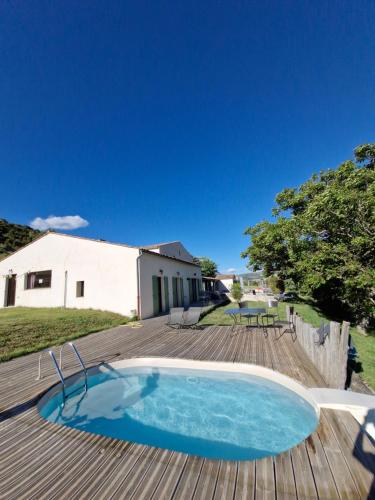 - une piscine sur une terrasse en bois avec un bâtiment dans l'établissement Domaine de la Graou, à La Palud-sur-Verdon