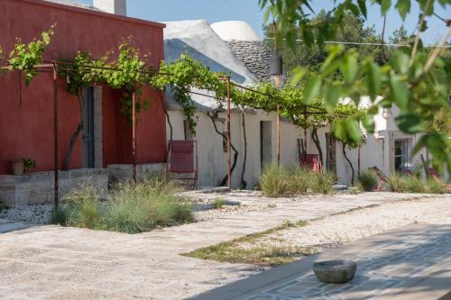 an old house with a red and white building at Alloggio nei Trulli della Masseria Collina Casanoja in Noci