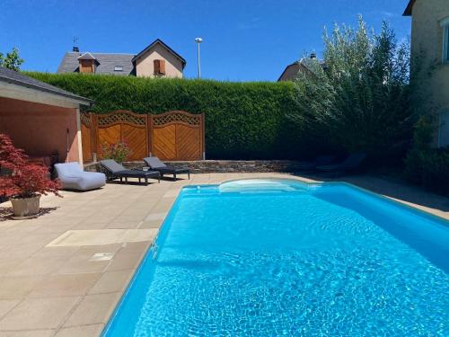 une grande piscine bleue dans une cour dans l'établissement Au coeur du Gévaudan appartement de plain pied, à Marvejols
