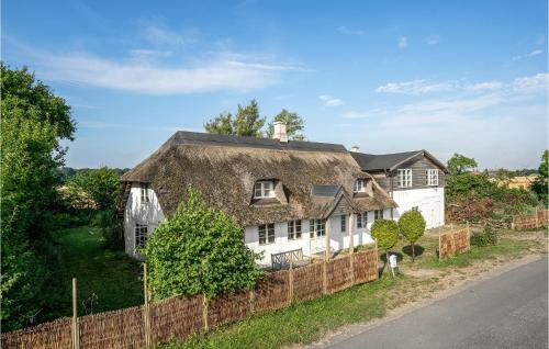SøllestedにあるNice Home In Søllested With Saunaの茅葺き屋根の古い白い家