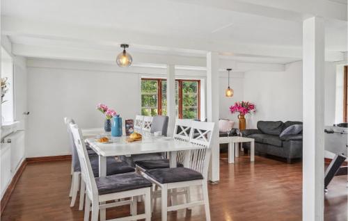 SøllestedにあるNice Home In Søllested With Saunaの白いテーブルと椅子のあるキッチンとダイニングルーム