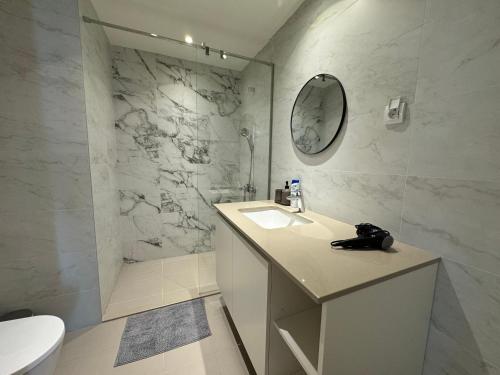 a white bathroom with a sink and a mirror at BW Arcadia deluxe apartments in Sajmište