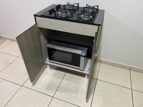 a stove top oven with a microwave in a kitchen at Pousada Locks, Cascavel, Paraná - 02 in Cascavel